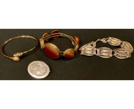 A Victorian agate bangle; a silver filigree bracelet; a silver gilt bangle; a silver gilt brooch 