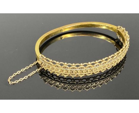 15CT HOLLOW GOLD BANGLE, filigree decoration to upper half, with safety chain, 60 x 50mms internal, 11gms, in original fitted