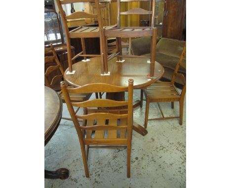 Elm Ercol centre or dining table on quatraform base, together with a set of six matching elm Ercol ladder back chairs. (7)(B.