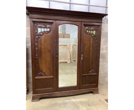 A late 19th century French Art Nouveau carved oak compactum wardrobe, width 205cm, depth 64cm, height 218cm