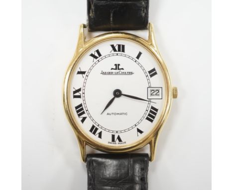 A gentleman's 18k Jaeger LeCoultre automatic dress wrist watch, with oval Roman dial and date aperture, on a leather strap wi