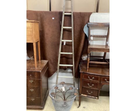 A vintage wooden window cleaner's ladder, height 250cm, two wirework garden baskets and a wrought iron candelabrum
