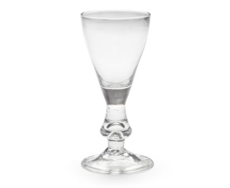 A rare drop-knopped heavy baluster wine glass, circa 1720The thin tulip-shaped bowl with a solid base extending into a wide d