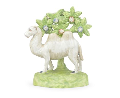 A rare Staffordshire model of a Bactrian camel, circa 1820-30Standing before bocage on an irregular green mound base, its coa