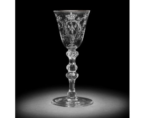 A fine and rare Dutch stipple-engraved Royal armorial light baluster wine glass by 'Gyrinus', circa 1765The round funnel bowl