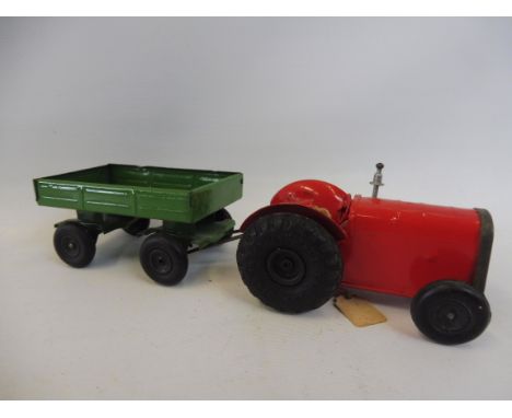 A Tri-ang Minic clockwork tinplate farm tractor and trailer.