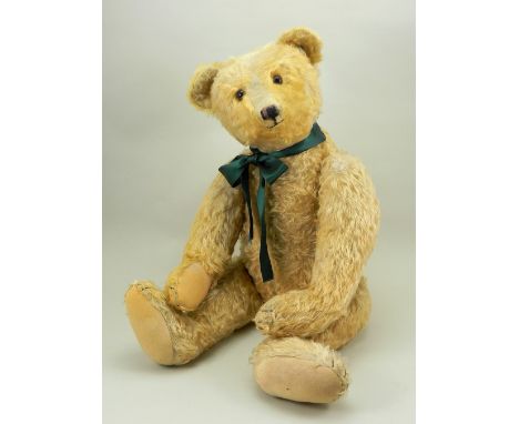 A large Steiff golden mohair Teddy bear, 1920s, button to left ear, the straw stuffed bear with brown glass eyes, black stitc