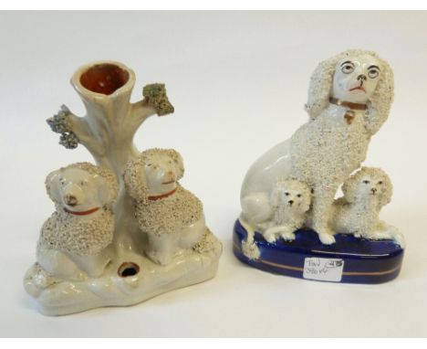 A VICTORIAN STAFFORDSHIRE POTTERY GROUP SEATED POODLE WITH TWO RECUMBENT PUPPIES each with textured detail on royal blue and 