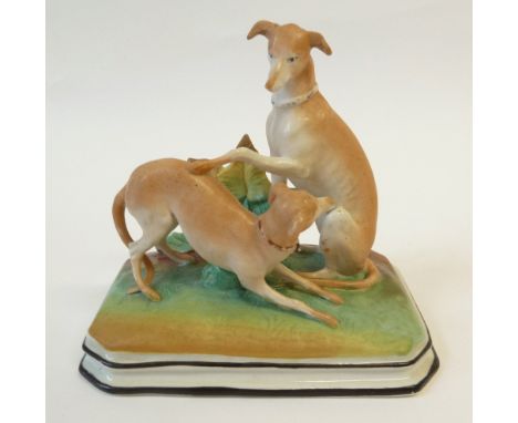 A LATE 19TH CENTURY TINTED BISQUE GROUP OF PLAYFUL WHIPPETS on oblong plinth base with cut away corners, 5½" (14cm) wide