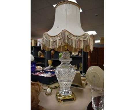 A large vintage cut crystal baluster table top lamp, having cream colour silk shade, standing on a brass base, h73cm.
Conditi