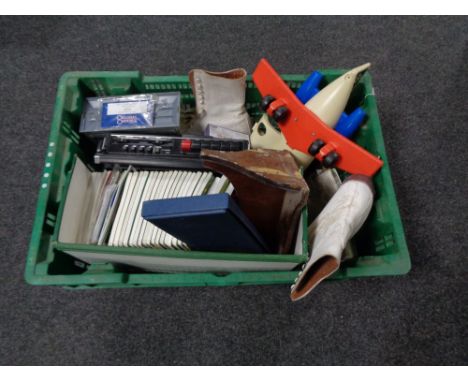A crate of cribbage board, vintage ice skates, etc, shopping trolley and three hard shell luggage cases 
