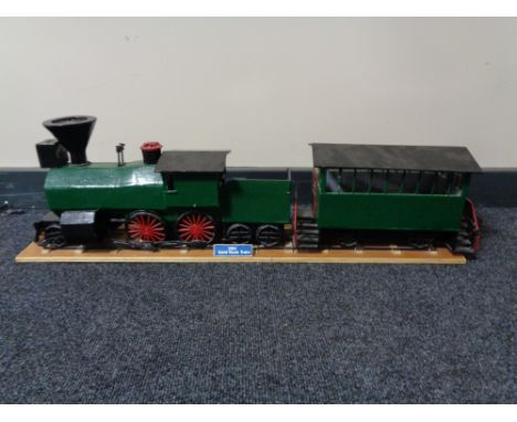 A hand built wooden model of a steam train with carriage