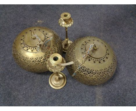 A pair of brass Moroccan style light shades together with a pair of Eastern brass candlesticks 