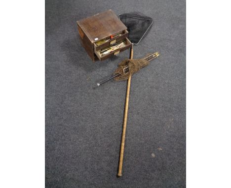 An early 20th century four drawer counter top chest containing fishing accessories together with two vintage landing nets 