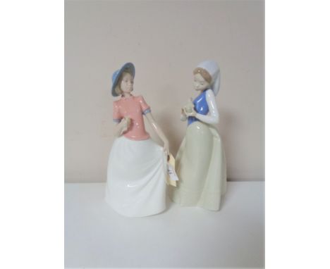 Two Nao figures - girl with chick and girl holding flower 