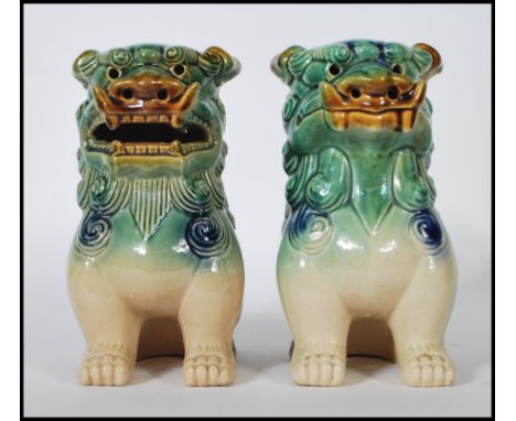 A pair of mid 20th Century Chinese porcelain temple lions / dogs of&nbsp; Fu. Both modeled with a jade coloured glaze on four