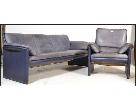 A 20th Century vintage Leolux lounge suite consisting of a three seater sofa and armchair , the body upholstered in a dark bl