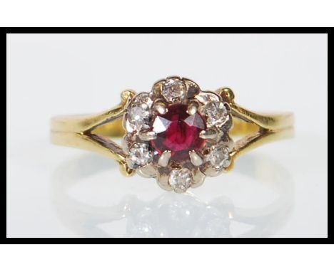 A hallmarked 18ct yellow gold ladies dress ring set with a round cut garnet with a halo of diamonds of approx 18pts having de