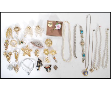 A collection of vintage costume jewellery to include predominantly brooches, bangle, pearl necklaces, pendant necklace, brace