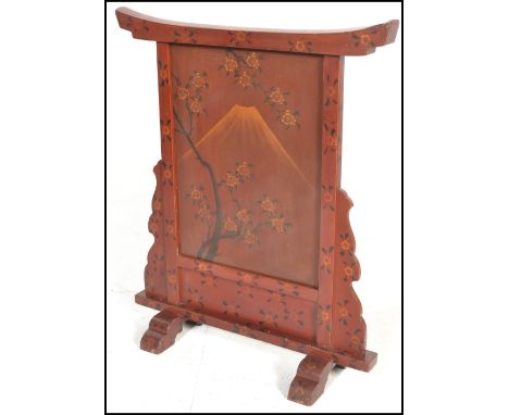 An early 20th Century Japanese red and black lacquer fire screen having the central front panel decorated with mount Fuji and