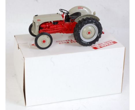 A Danbury Mint 1:16 scale model of a 1952 Ford 8M tractor, comprising grey and red body with grey hubs, in the original polys