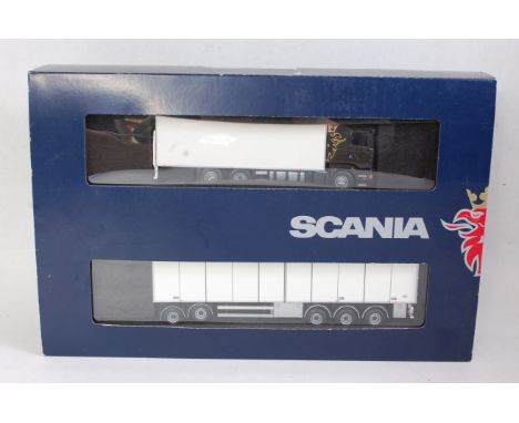 A Tekno 1:50 scale boxed model of a Scania R580 V8 6x2 Highline rigid truck with matching 5 axle draw bar box trailer, sold i