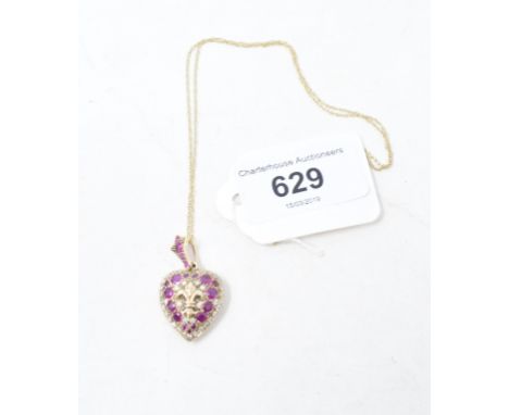 A 9ct gold, ruby and diamond heart shape locket, with a fleur-de-lys motif, on a 9ct gold chainReport by NGModern 