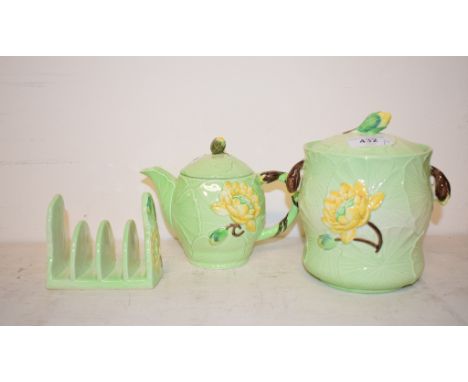 A Carlton Ware Yellow Lily teapot and cover, 1786 (?), 13 cm high, a similar toast rack, a biscuit jar and cover, slight rest