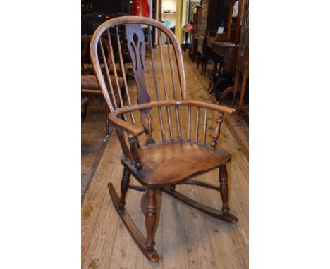 A late 19th century kitchen stick back rocking armchair, with a crinoline stretcher 