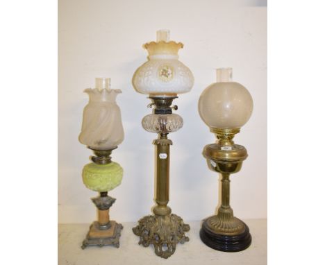 A large brass table lamp, with clear glass reservoir, 81 cm high, and two others, 66 cm and 63.5 cm high (3)Report by GHGener