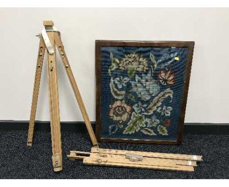 A framed floral tapestry and two artist's easels 
