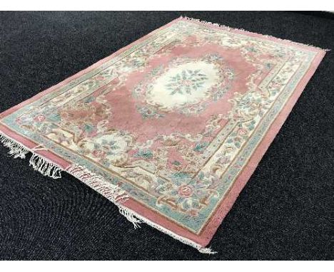 A pink Chinese fringed carpet 