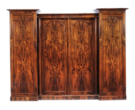 Ω A Victorian rosewood triple section clothes press , by J. Kendell &amp; Co., circa 1840, the central pair of panelled doors