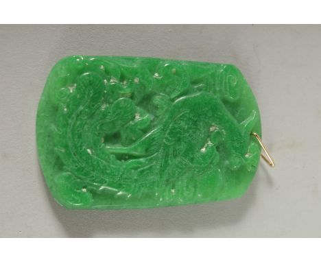 A CARVED JADE PENDANT with gold ring. 2.5ins.
