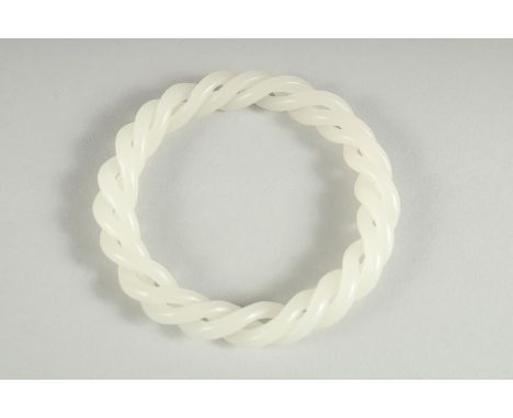A JADE WHITE TWIST BANGLE. 3ins diameter.