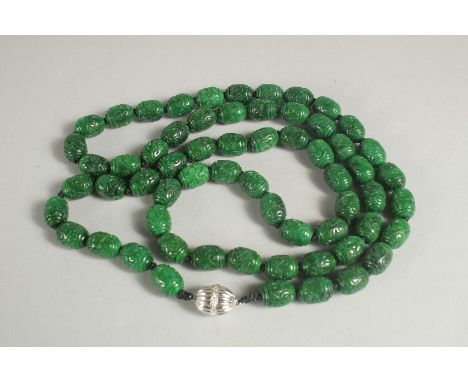 A LONG CARVED JADE NECKLACE with white gold clasp. 38ins long.