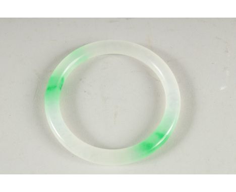 A TWO TONE JADE BANGLE. 3ins diameter.