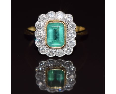 An 18ct gold ring set with an emerald cut emerald of approximately 1ct surrounded by diamonds, 3.4g, size O