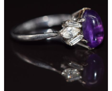 An 18ct white gold ring set with an amethyst cabochon, marquise cut diamonds and baguette cut diamonds in a platinum setting,