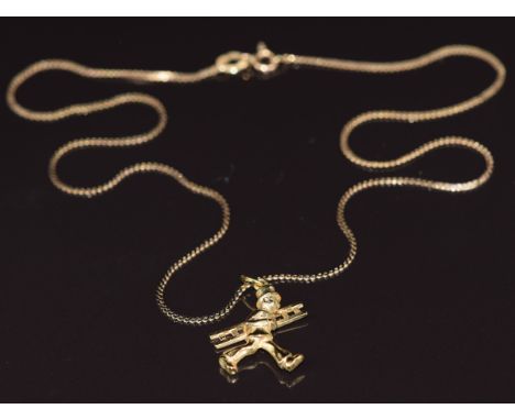 A 14k gold pendant in the form of a man carrying a ladder, on a 14k gold chain, 3.4g