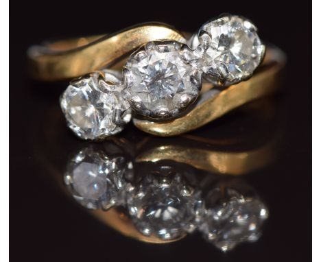 An 18ct gold ring set with three round brilliant cut diamonds in a twist setting, total diamond weight approximately 1ct, 3.9