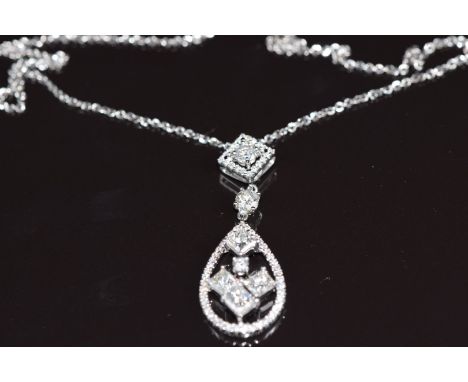 An 18ct white gold pendant set with four princess cut diamonds and further round brilliant cut diamonds, total diamond weight