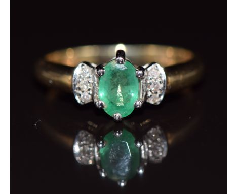 A 9ct gold ring set with an oval cut emerald and diamonds, 1.6g, size H