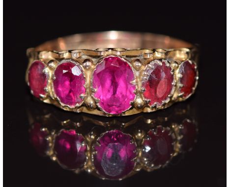 A 9ct gold ring set with synthetic rubies and tourmaline, Birmingham 1920, 2.5g, size N