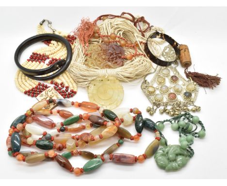 A large agate necklace, three jade style carved pendants, a large white metal pendant set with agate, carved bone snake bangl