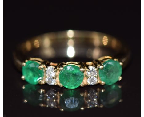 An 18ct gold ring set with three round cut emeralds, each approximately 0.35ct, and diamonds, 4.5g, size R