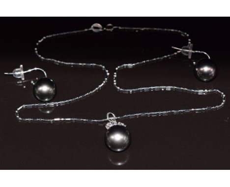 An 18ct white gold pendant set with a 13ct black South Sea pearl, three marquise cut diamonds and two round cut diamonds, on 