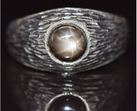 An 18k white gold ring set with a star sapphire, 7.8g, size X