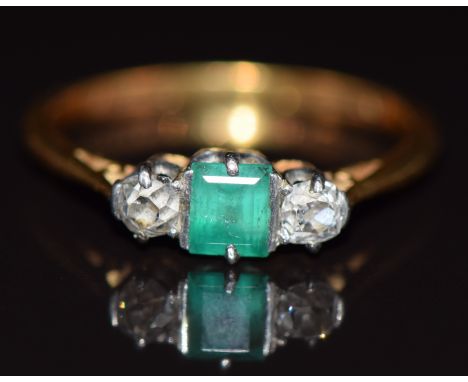 An 18ct gold ring set with an emerald and old cut diamonds in a platinum setting, 2.2g, size L