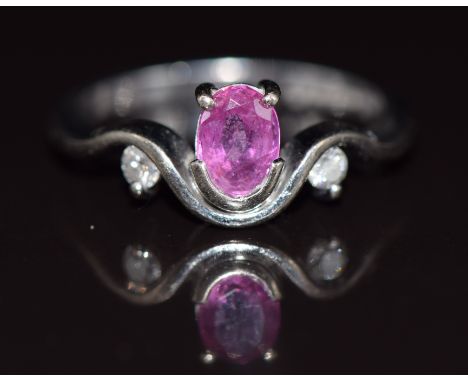 An 18ct white gold ring set with an oval cut pink sapphire of approximately 0.5ct and diamonds, 4.1g, size M